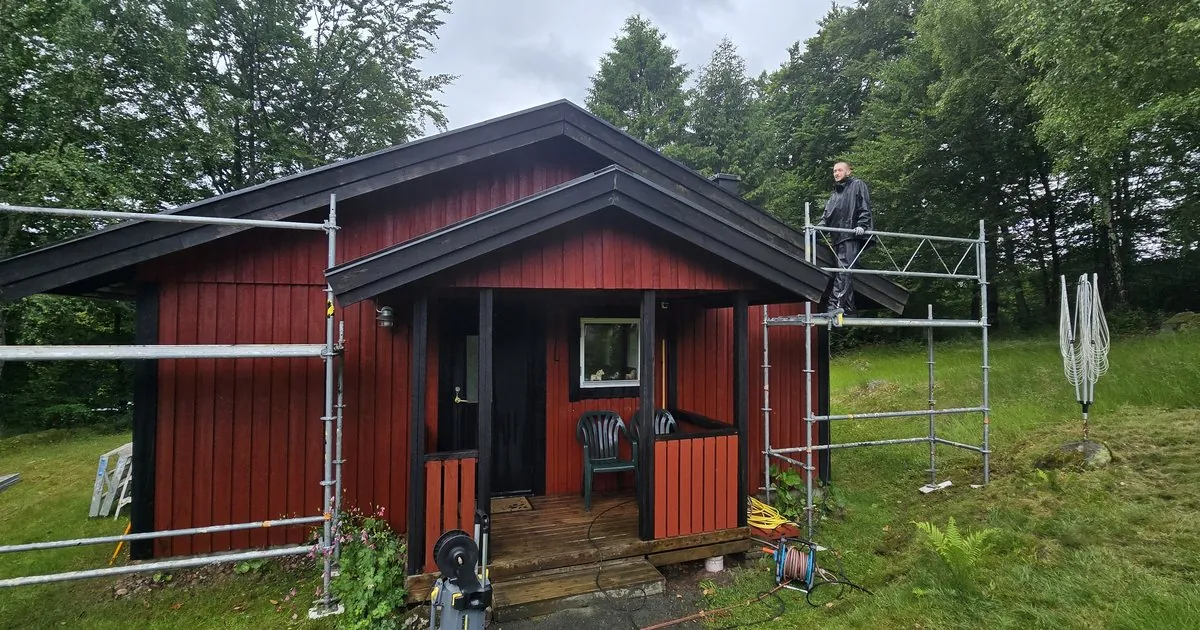 Röd träfasad med byggnadsställning