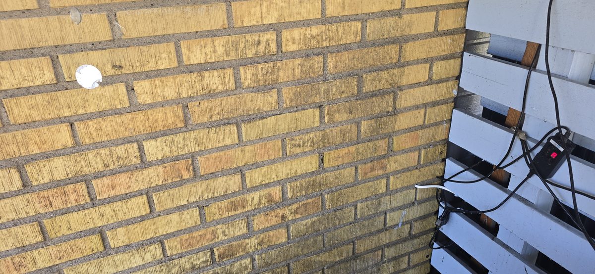 Omålad gul tegelfasad på ett hus i Åkarp, där det gula teglet möter en vitmålad putsdel – utgångsläget innan kulörvalet