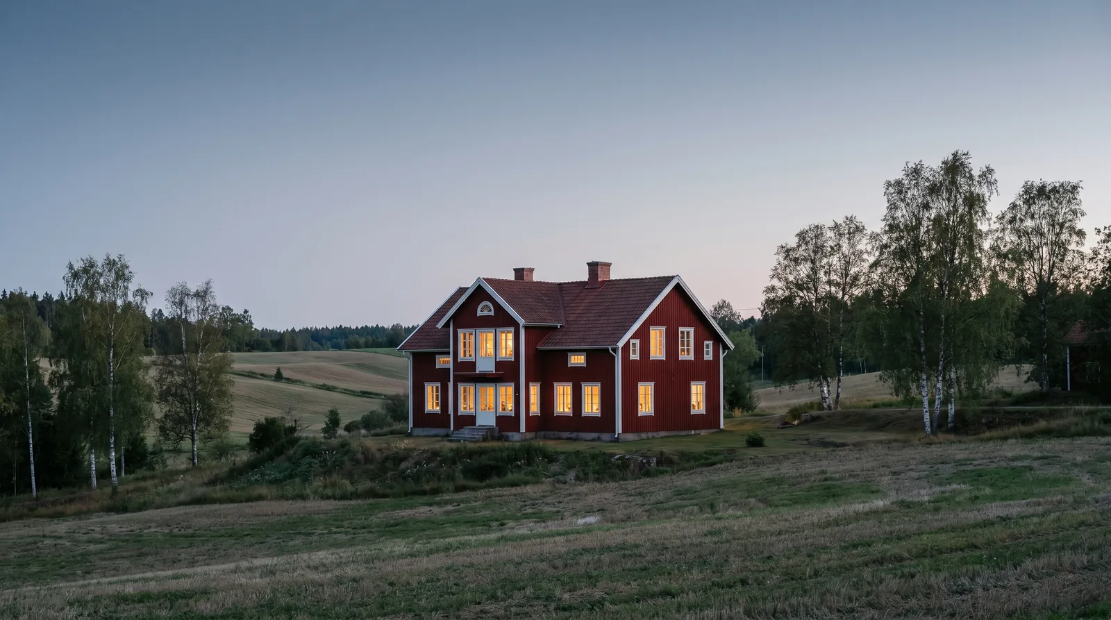 Nymålad villa i skymning efter utvändig fasadmålning i Skåne
