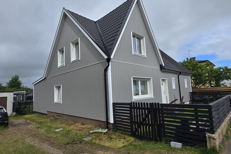 Villa i Klippan med grå stående träpanel och vita fönsterfoder efter träfasadmålning av NLL Måleri