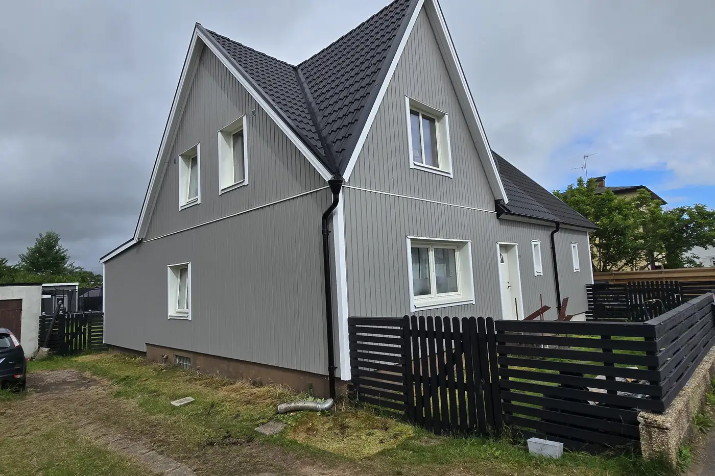 Ommålad grå stående träpanel på villa i Klippan